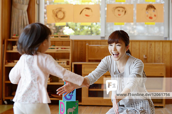 Erzieherin mit Kind im japanischen Kindergarten
