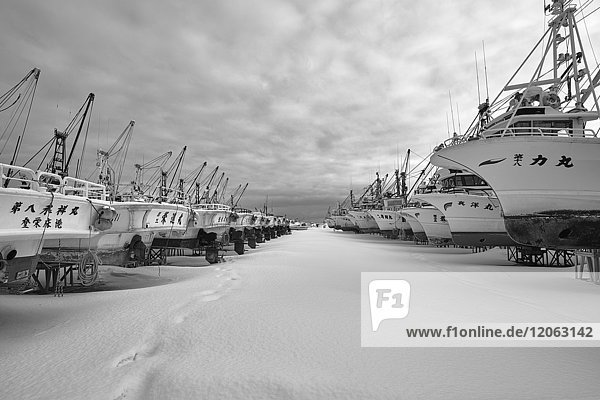Reihe von Fischerbooten auf trockenen Plattformen im Winter.