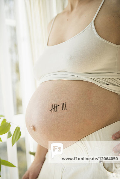 Schwangere Frau mit Strichlistensymbol auf dem Bauch