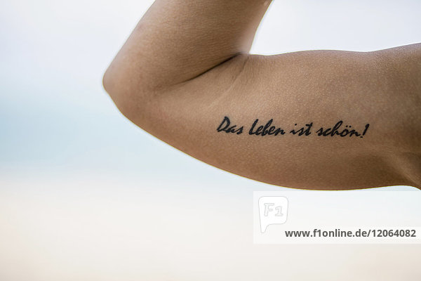 Tätowierung auf dem Arm ''Das Leben ist wunderbar''