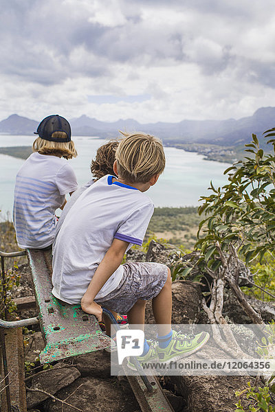 Three children looking at the Indian Ocean from a viewpoint