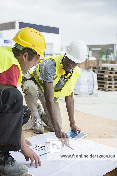 Bauarbeiter bei der Überprüfung eines Bauplans auf der Baustelle
