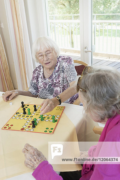 Ältere Frauen spielen ein Brettspiel im Altersheim