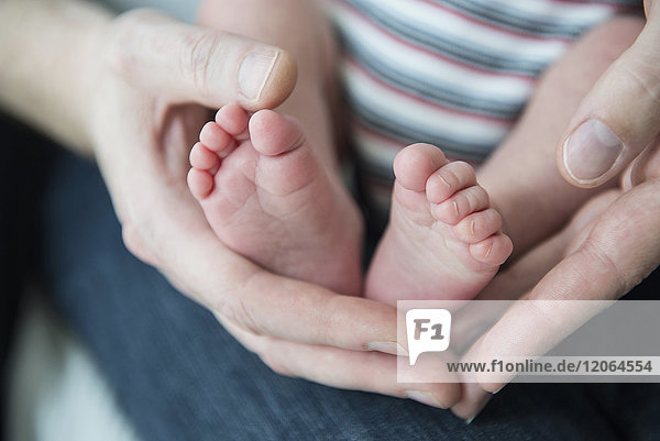 Nahaufnahme einer Mutter  die die Füße ihres neugeborenen Babys hält