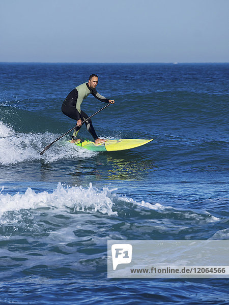 Man surfing with a stand up paddling board at sopelana beach