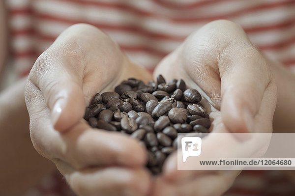 Hands full with coffee beans