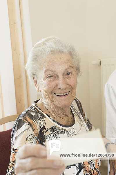 Ältere Frau betrachtet Foto im Altersheim