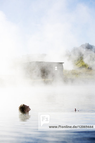 A woman bathing in The Secret Lagoon in Iceland