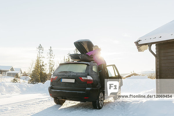 Frau beim Auspacken eines Autos im Winter