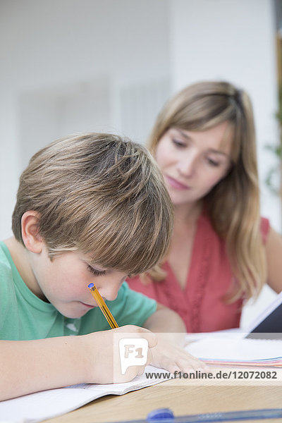 Ein Kind macht mit seiner Mutter Hausaufgaben.