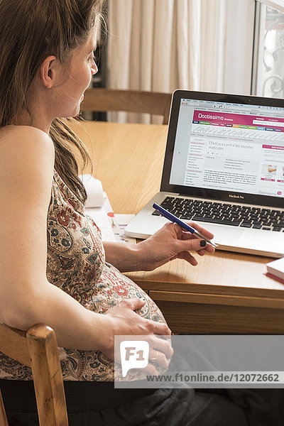 Schwangere Frau  die sich auf einer Gesundheitswebsite informiert.