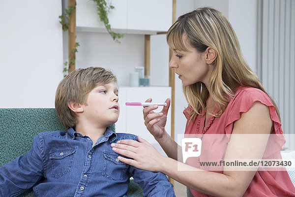 Eine Mutter gibt ihrem Sohn Paracetamol.
