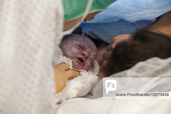 Reportage aus der Entbindungsstation des Krankenhauses Métropole Savoie in Chambéry  Frankreich. Eine geplante Entbindung per Kaiserschnitt. Eine Krankenschwester bringt das Baby zu seiner Mutter.