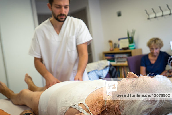Reportage in einer Osteopathiepraxis in Héyrieux  Frankreich. Osteopathie-Sitzung für eine 98-jährige Frau  die unter Rücken- und Arthroseschmerzen leidet.