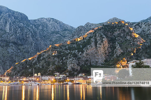 Venetian built fort with bastions highlighted by lights at twilight  Kotor  Montenegro  Europe