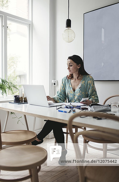 Geschäftsfrau mit Laptop auf dem Tisch im Home-Office