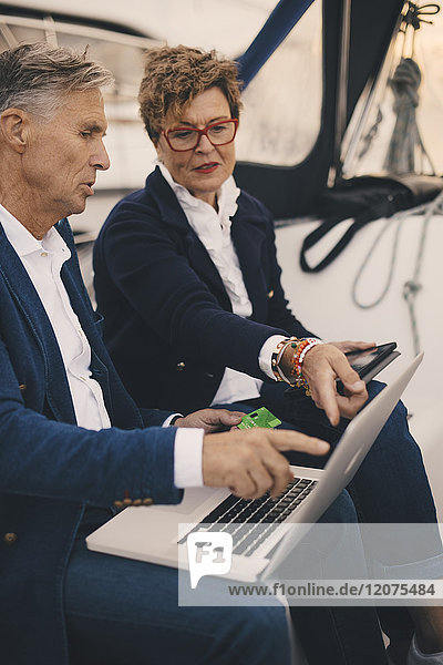 Senior Paar diskutiert über Laptop während der Reise in der Yacht