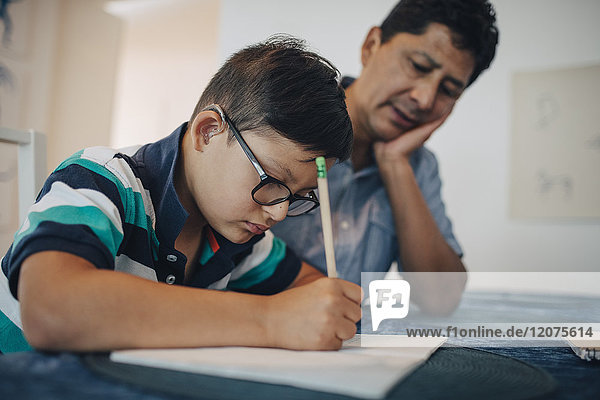 Vater lehrt behinderten Sohn beim Sitzen am Tisch