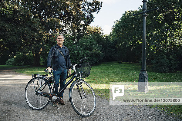 Porträt eines älteren Mannes mit Fahrrad im Park