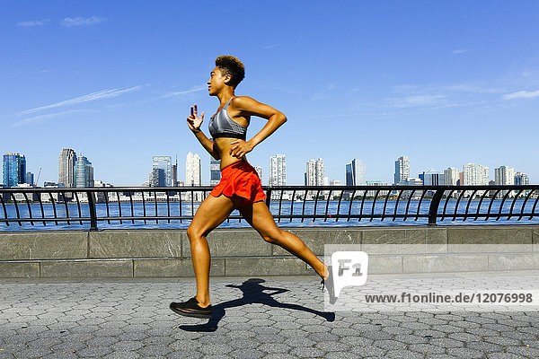 Mixed race woman running at waterfront