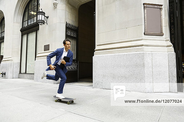 Caucasian businessman skateboarding on urban sidewalk