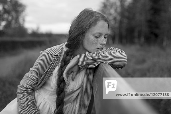 Pensive Caucasian girl sitting on bench
