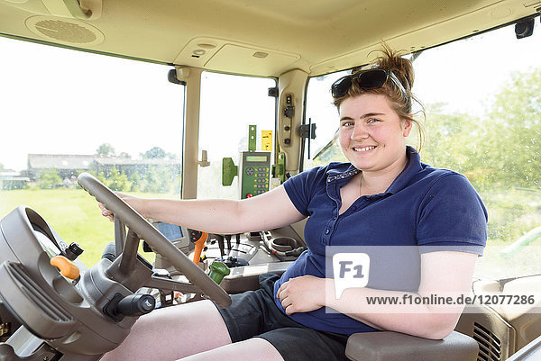 Portrait of smiling Caucasian woman driving tractor