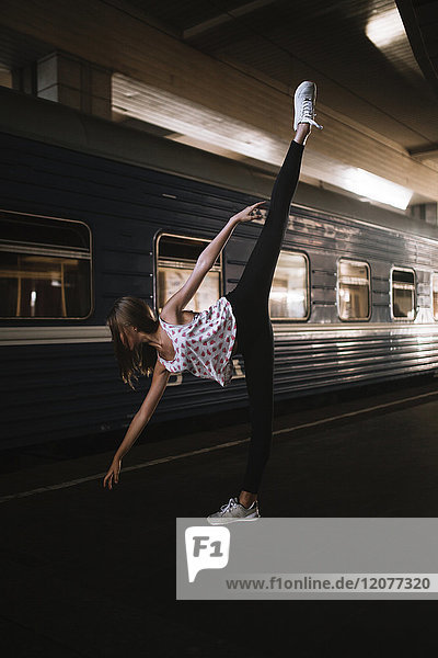Caucasian woman dancing near train