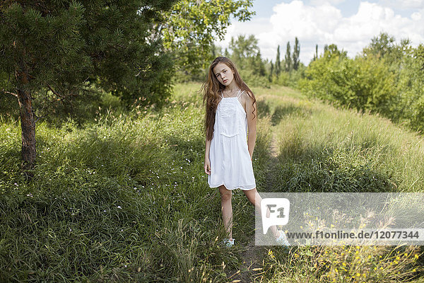 Caucasian girl standing in field of grass