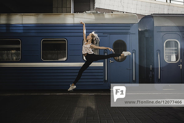 Caucasian woman dancing near train