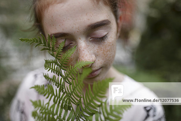 Caucasian girl smelling leaves