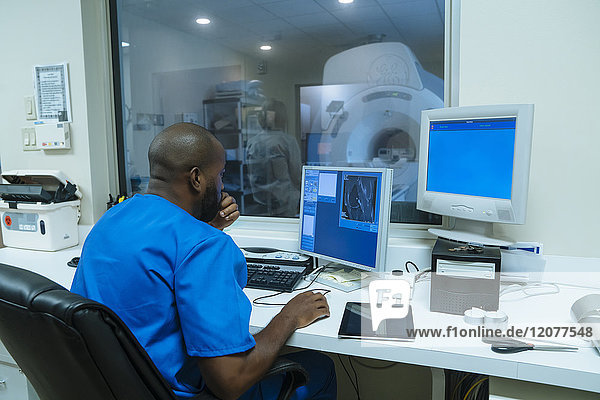 Black nurse using computer near scanner