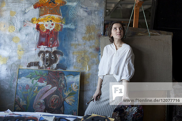 Caucasian artist holding paintbrush and palette