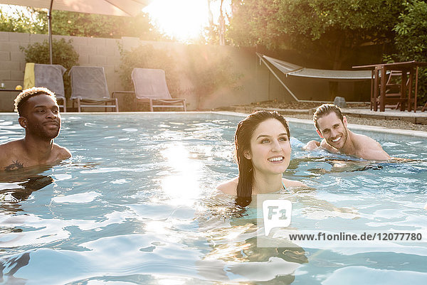 Lächelnde Freunde entspannen sich im Schwimmbad