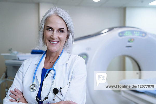 Portrait of smiling Caucasian doctor near scanner