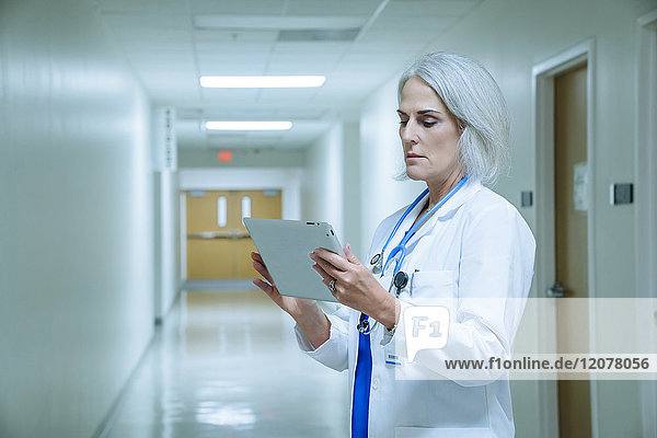 Kaukasischer Arzt verwendet digitales Tablet im Krankenhaus