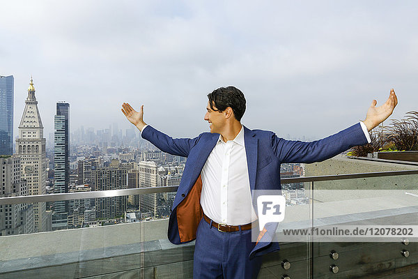 Caucasian businessman celebrating on urban rooftop