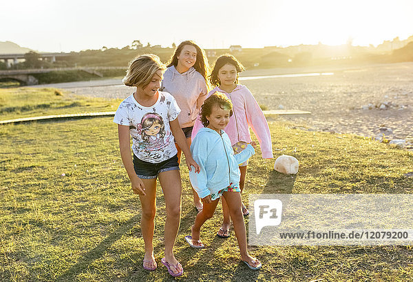 Four girls playing outdoors at sunset girls on boardwalk