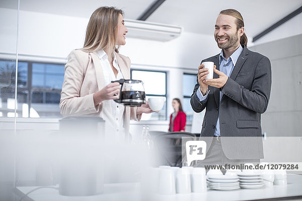Businessman and businesswoman having coffee in office