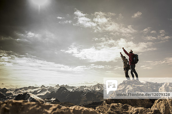 Germany  Bavaria  Oberstdorf  two hikers cheering on rock in alpine scenery