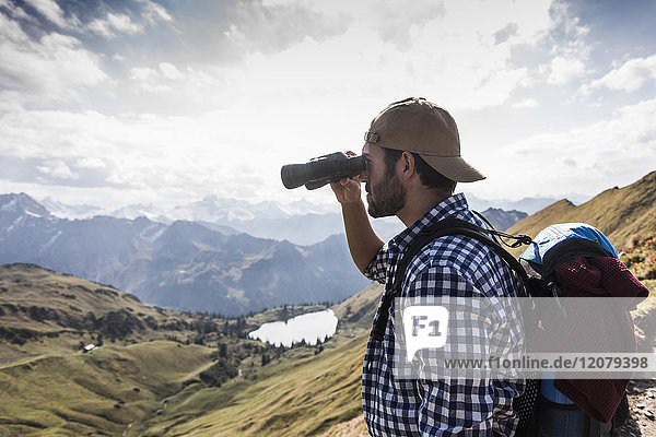 Deutschland  Bayern  Oberstdorf  Wanderer mit Fernglas in alpiner Umgebung