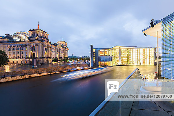Deutschland  Berlin  Blick auf beleuchteten Reichstag und Paul-Loebe-Gebäude mit Spree im Vordergrund