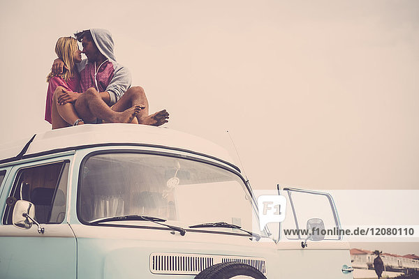 Spanien  Teneriffa  junges verliebtes Paar auf dem Autodach eines Lieferwagens sitzend