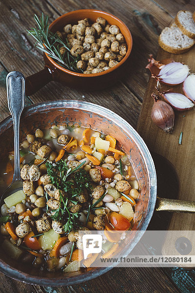 Mediterrane Suppe im Kupferkessel  Schüssel mit Croutons und Zutaten auf Holzbrettchen