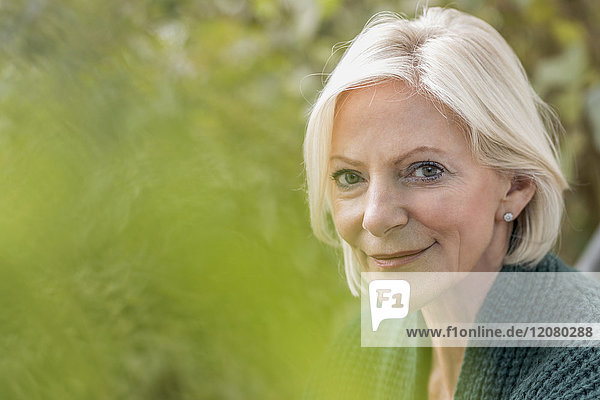 Porträt einer lächelnden Seniorin in der Natur