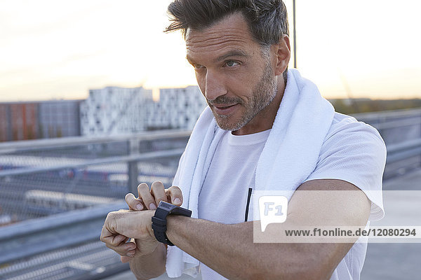 Athlete in the city with smartwatch and towel