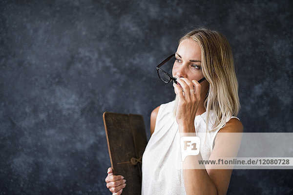 Woman with glasses holding wooden board