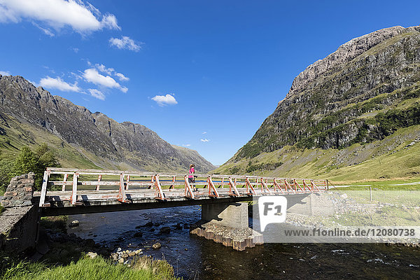 Großbritannien  Schottland  Schottische Highlands  Glencoe  Loch Achtriochtan  weibliche Touristen  die über die Brücke laufen