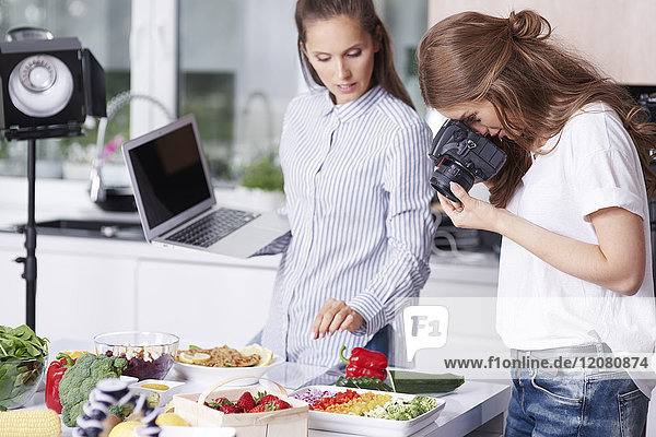 Frau fotografiert Essen in der Küche
