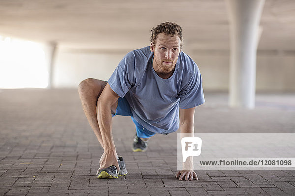 Sportive man stretching before exercising